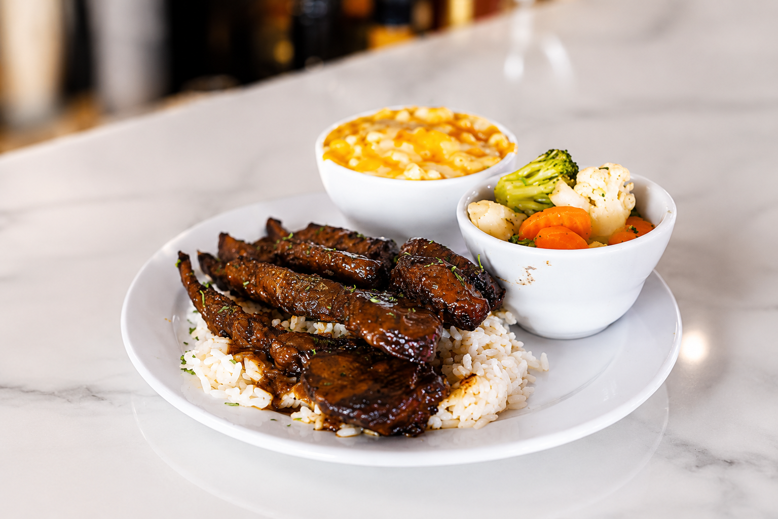 Editorial photograph of a Jamaican entrée plated with rice and sides